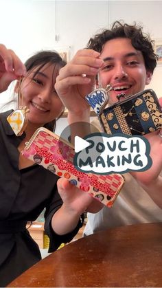 two people holding up small objects with the words povich making on them