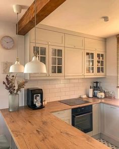 a kitchen with wooden counter tops and white cabinets