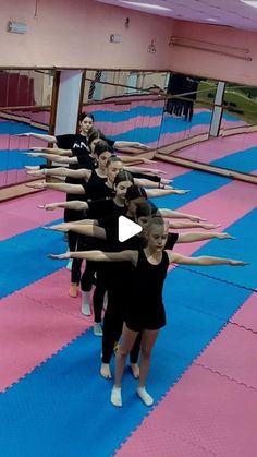 a group of young women standing on top of a blue and pink floor next to each other