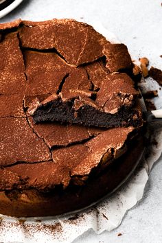 a chocolate cake on a plate with one piece cut out and the other half eaten