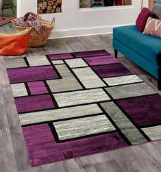 a living room with a blue couch and purple rug