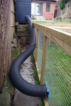 a black hose is attached to the side of a fence