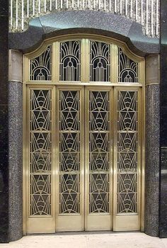 an ornate glass door on the side of a building with stairs leading up to it