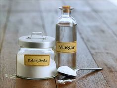 a bottle of baking soda next to a salt shaker and spoon on a wooden table