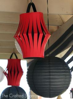 three red and black paper lanterns hanging from the ceiling