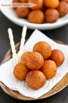 some food that is sitting on top of a wooden plate with white sticks in it