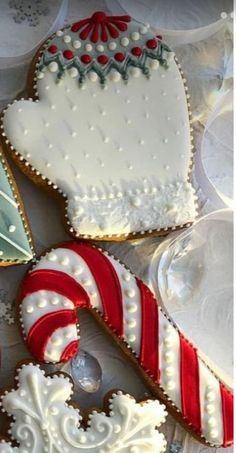 three decorated cookies sitting next to each other on top of a white table covered in frosting