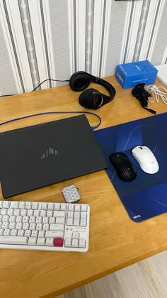 a desk with a laptop, keyboard and mouse on it