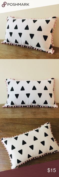 two pillows with black and white triangles on them, one is pink and the other is blue