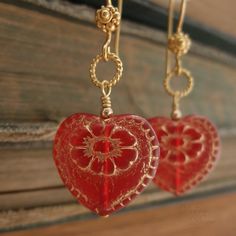 "Beautiful red glass hearts, etched in gold, hang from delicate, twisted wire loops and decorative earwires of vermeil. A lovely gift for yourself or somebody else on Valentine's Day. Length from bottom loop of earwire: 1\"(25mm) Diameter of heart: 3/4\"(20mm) All Debra Dane jewelry arrives in a pretty box suitable for gifting. These earrings are also available with non-pierced gold plated clips. They will have a gold ball instead of the ornate piece that is on the pierced earwires." Wire Wrapped Jewelry For Valentine's Day Anniversary, Valentine's Day Wire Wrapped Jewelry For Anniversary, Red Double Heart Earrings As Gift, Red Dangle Heart Earrings As A Gift, Red Dangle Heart Earrings For Gift, Red Double Heart Earrings For Gift, Heart-shaped Jewelry With Ear Wire For Gifts, Elegant Red Heart Earrings For Gift, Red Brass Jewelry For Anniversary