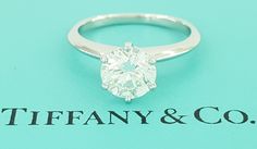 a diamond ring sitting on top of a blue box with the word tiffany & co written below it