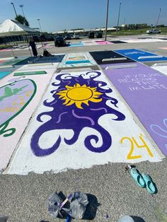 some people are painting on the ground with numbers and symbols in front of an empty parking lot