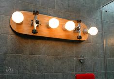 a skateboard mounted to the side of a wall with five light bulbs on it