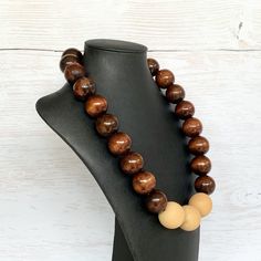 This chunky wood necklace was hand beaded using a mix of large 25mm round dark brown and 28mm round medium tone tan wooden beads in a modern color block design. The necklace measures 24 inches long and is securely fastened with a silver clasp.  Perfect for any gender!  Length can be adjusted if needed - just ask! Wood represents a sense of earthiness, spirituality, creativity, liberty, prosperity, health, and natural touch.  Perfect for meditation, prayer, yoga practices, and everyday wear!    C Brown Round Beaded Necklace With Large Beads, Brown Beaded Necklace With Large Round Beads, Brown Wooden Beads Round Jewelry, Wooden Jewelry With Large Round Beads, Brown Wooden Beads Jewelry, Brown Round Wooden Beads Jewelry, Handmade Brown Round Beaded Necklaces, Brown Wooden Beaded Jewelry, Handmade Brown Beaded Necklaces