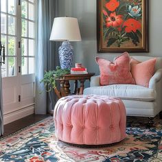 a living room filled with furniture and a large painting on the wall above an ottoman