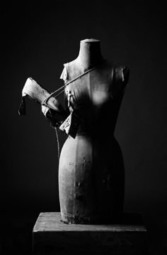 a black and white photo of an old vase with broken glass on the top, in front of a dark background