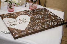 a table with two vases filled with flowers on top of it and a sign that says happy anniversary