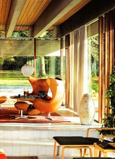 a living room filled with lots of furniture and large glass doors leading to an outdoor swimming pool