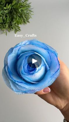 a hand holding a blue flower with the words easy crafts on it and an image of a