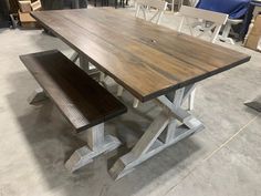 a wooden table with two benches next to it in a room filled with chairs and tables