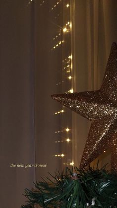 a star ornament on top of a christmas tree