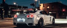 a white sports car parked in front of a traffic light