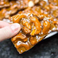 a hand holding up a piece of caramel pretzel