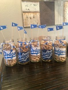 several jars filled with peanuts sitting on top of a wooden table