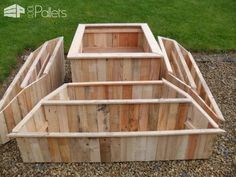 three wooden boxes sitting on top of gravel