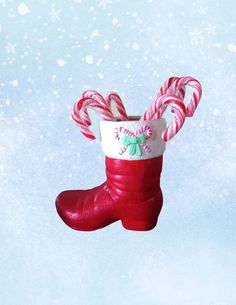 a red boot with candy canes hanging from it