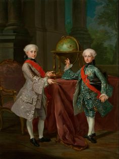 two young men standing next to each other in front of a table with a globe on it