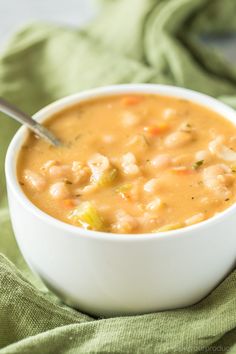 a white bowl filled with soup on top of a green cloth