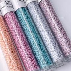 five different colors of beads in plastic tubes