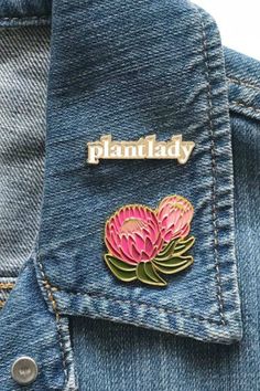 a pink flower pin sitting in the pocket of a jean jacket with gold lettering that says plant lady on it