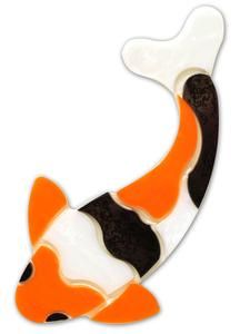 an orange and white koi fish with black spots on it's back legs