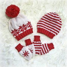 three knitted hats and mittens are laying on a white furnishing area