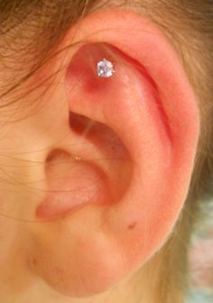 a close up of a person's ear with a diamond in it