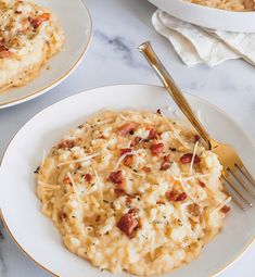 two plates with macaroni and cheese on them, one has a fork in it