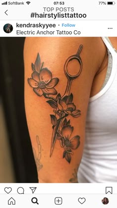 a woman with a tattoo on her arm holding a scissors and flowers in front of her shoulder