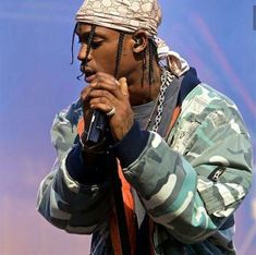 a man with dreadlocks on his head holding a microphone