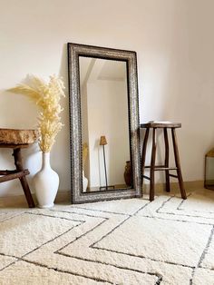 a large mirror sitting on top of a white rug