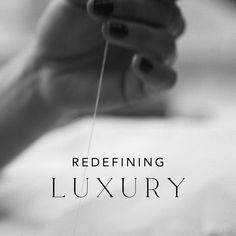 black and white photograph of a woman's hands holding a needle with the words redeffining luxury on it