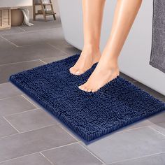 a person standing on a blue bath mat in a bathroom next to a white toilet