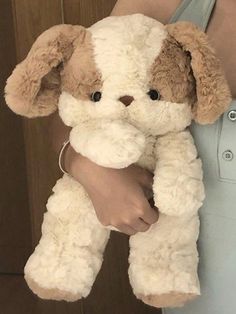 a person holding a stuffed dog in their hands