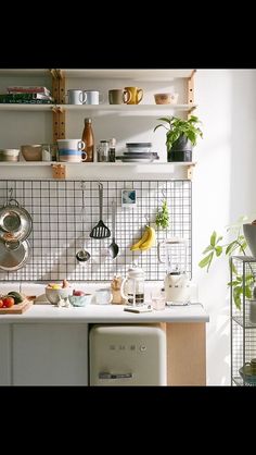 a kitchen with pots and pans on the wall next to a stove top oven