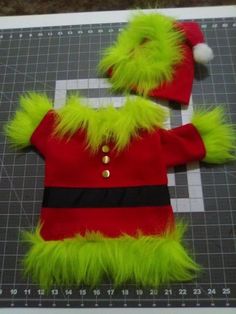 a green and red outfit sitting on top of a cutting board