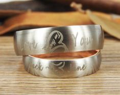 two wedding rings with engraved names on them