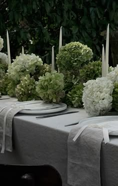 the table is set with white flowers and candles