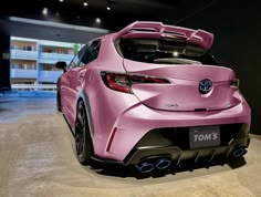 the rear end of a pink sports car