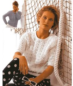 a woman sitting on top of a chair wearing polka dot pants and a white sweater